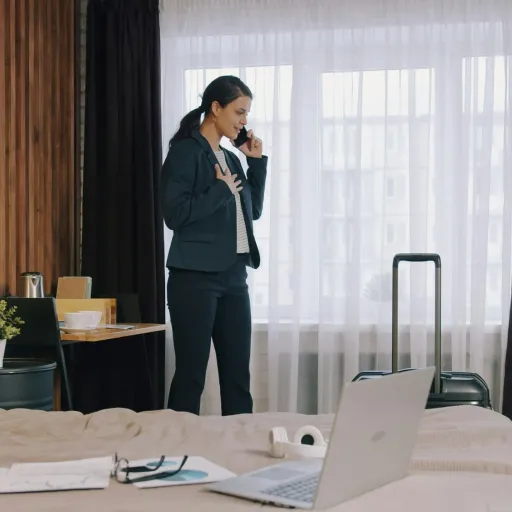 Voyageuse au téléphone dans une chambre d'hôtel avant son départ