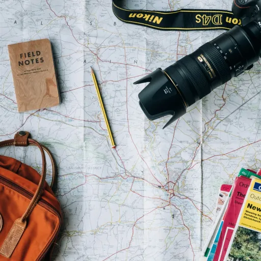 Préparation d'un voyage : carte, carnet, appareil photo et sac à dos