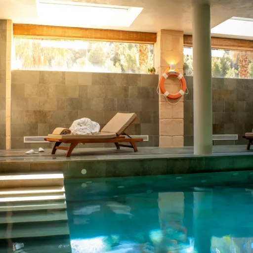 Piscine intérieure d'un hôtel spa avec chaises longues