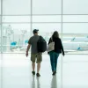 Couple de voyageurs traversant un terminal d'aéroport lumineux
