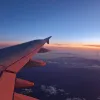 Aile d'avion au-dessus des nuages au coucher du soleil