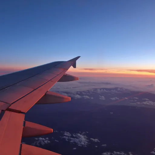 Aile d'avion au-dessus des nuages au coucher du soleil